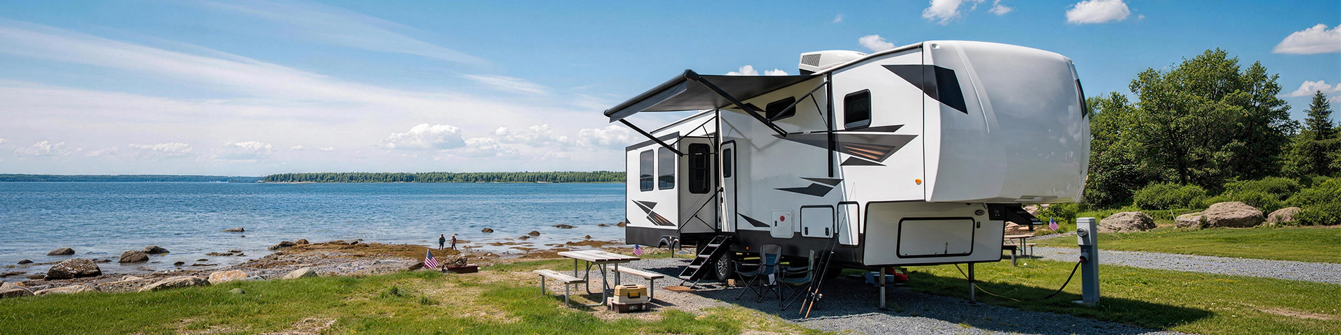 An RV parked beside a serene lake, surrounded by trees and misty fog, showcasing a peaceful outdoor setting.